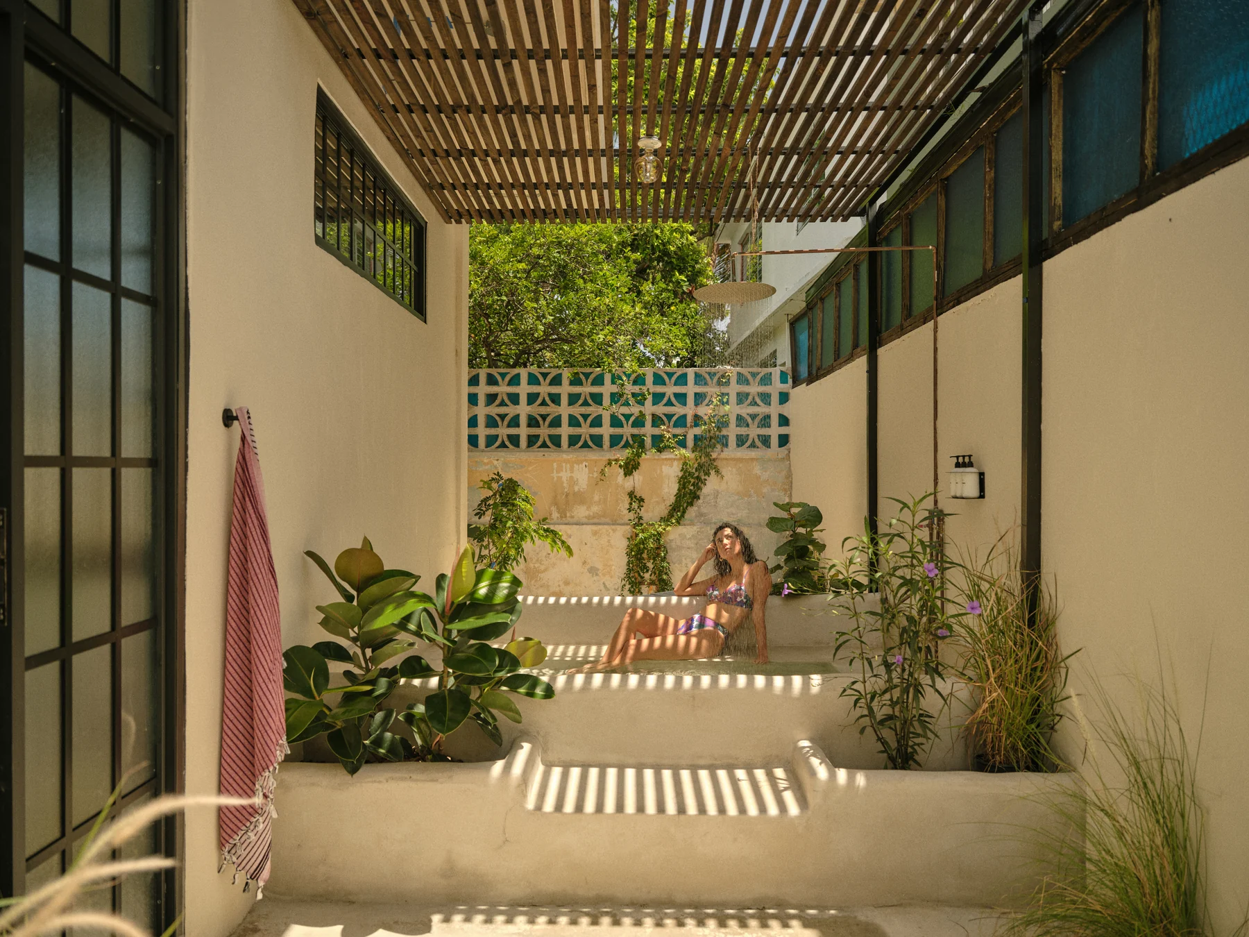 Paz 3’s private concrete soaking tub, planted patio and tall black-paned windows