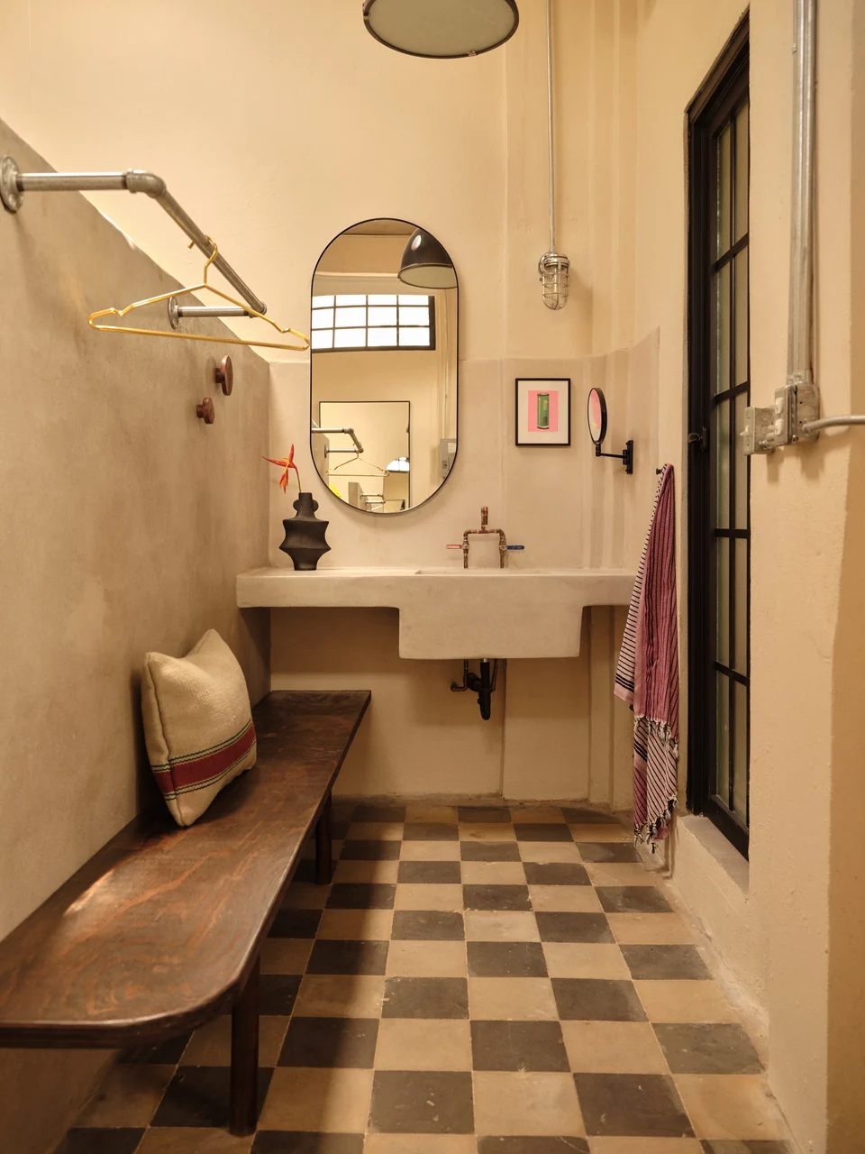 A round mirror, broad vanity and original patterned floor in Paz 1’s bathroom