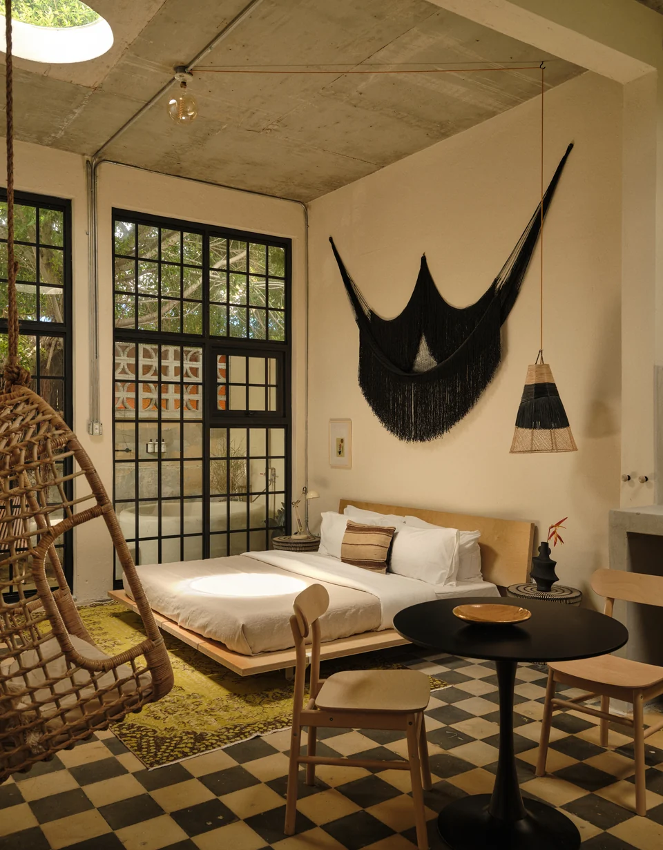 Original checkerboard tiles, a low lounge and hanging chair in Paz 1
