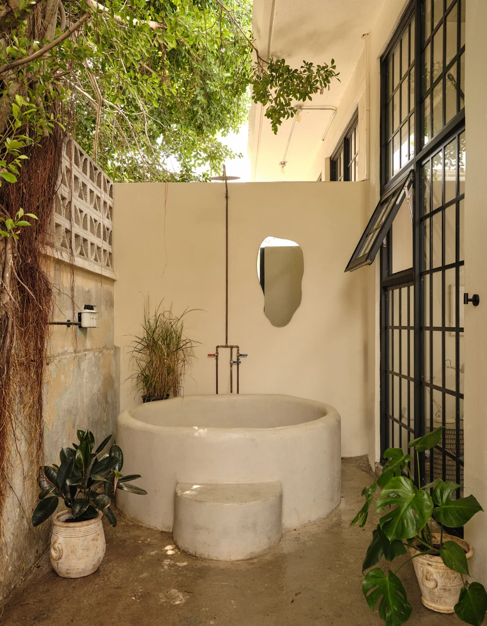 Paz 1’s private concrete soaking tub and outdoor shower in its planted patio
