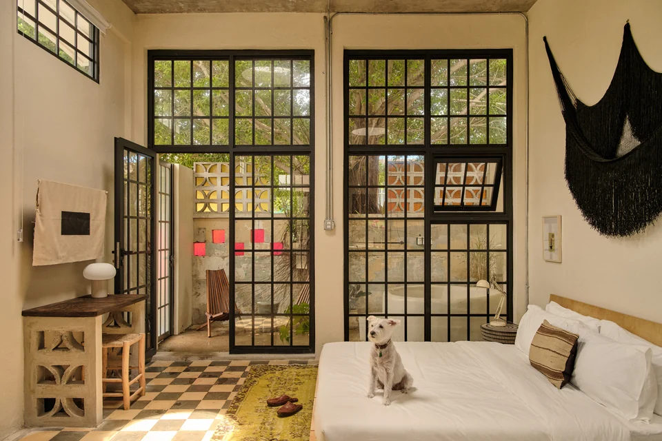 Paz 1’s king bed, tall black-paned windows and original checkerboard floor