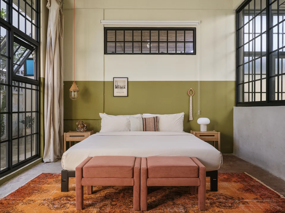 Paz 3’s king bed, tall windows and warm patterned rug