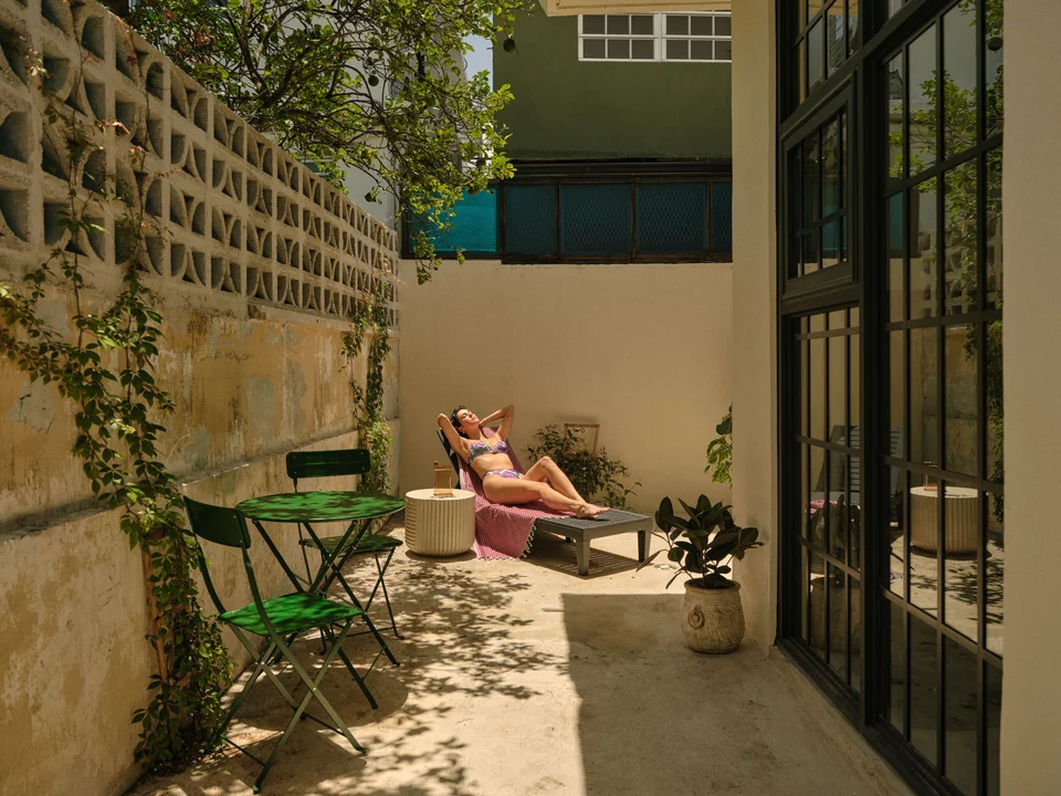 Green patio furniture, lounge seating and tropical planting on Paz 3’s private terrace