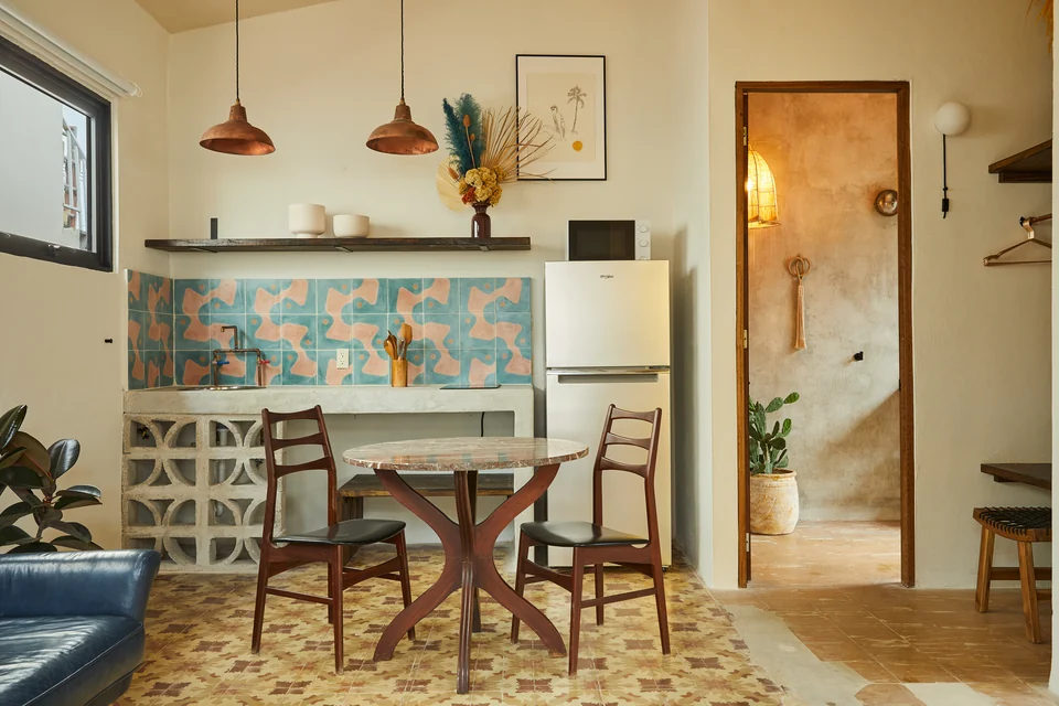A floral tiled backsplash, copper pendants and dining table in Rosa 1’s kitchenette