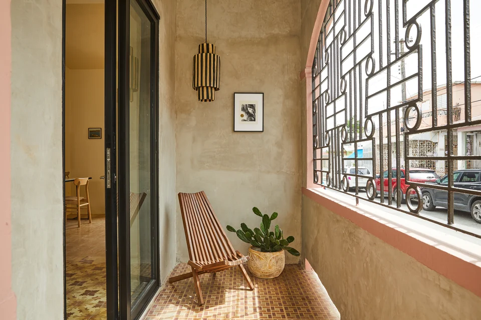 Rosa 1’s shaded balcony with a reclining chair, plants and decorative metalwork