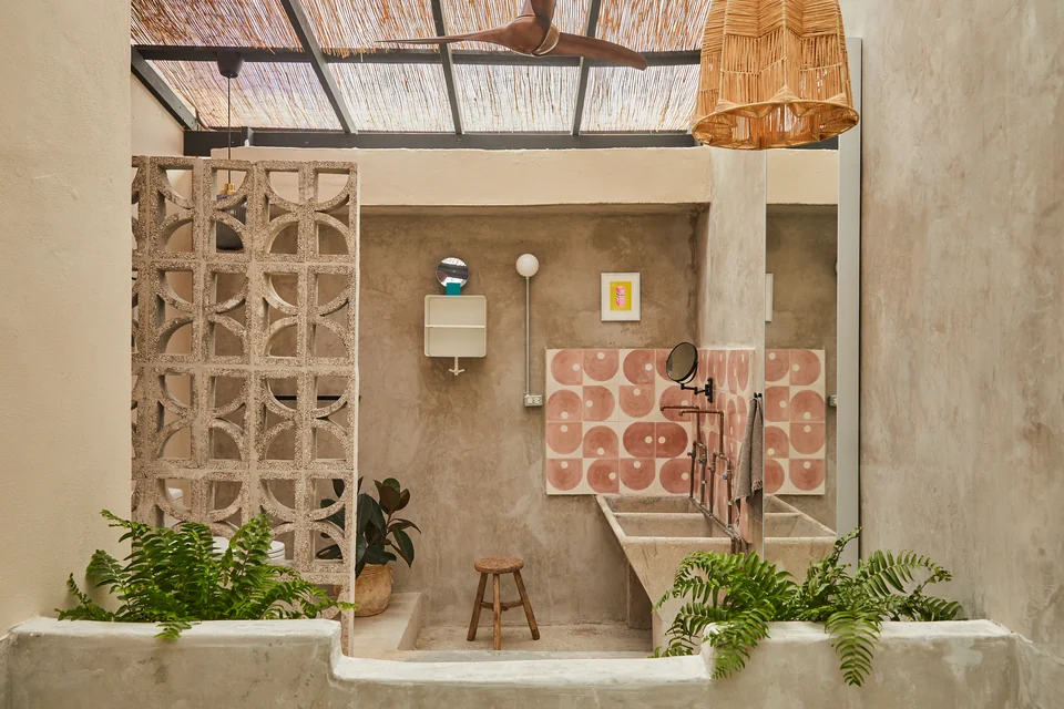 Rosa 2’s private outdoor bathroom with a concrete tub, vanity and planted breeze-block wall