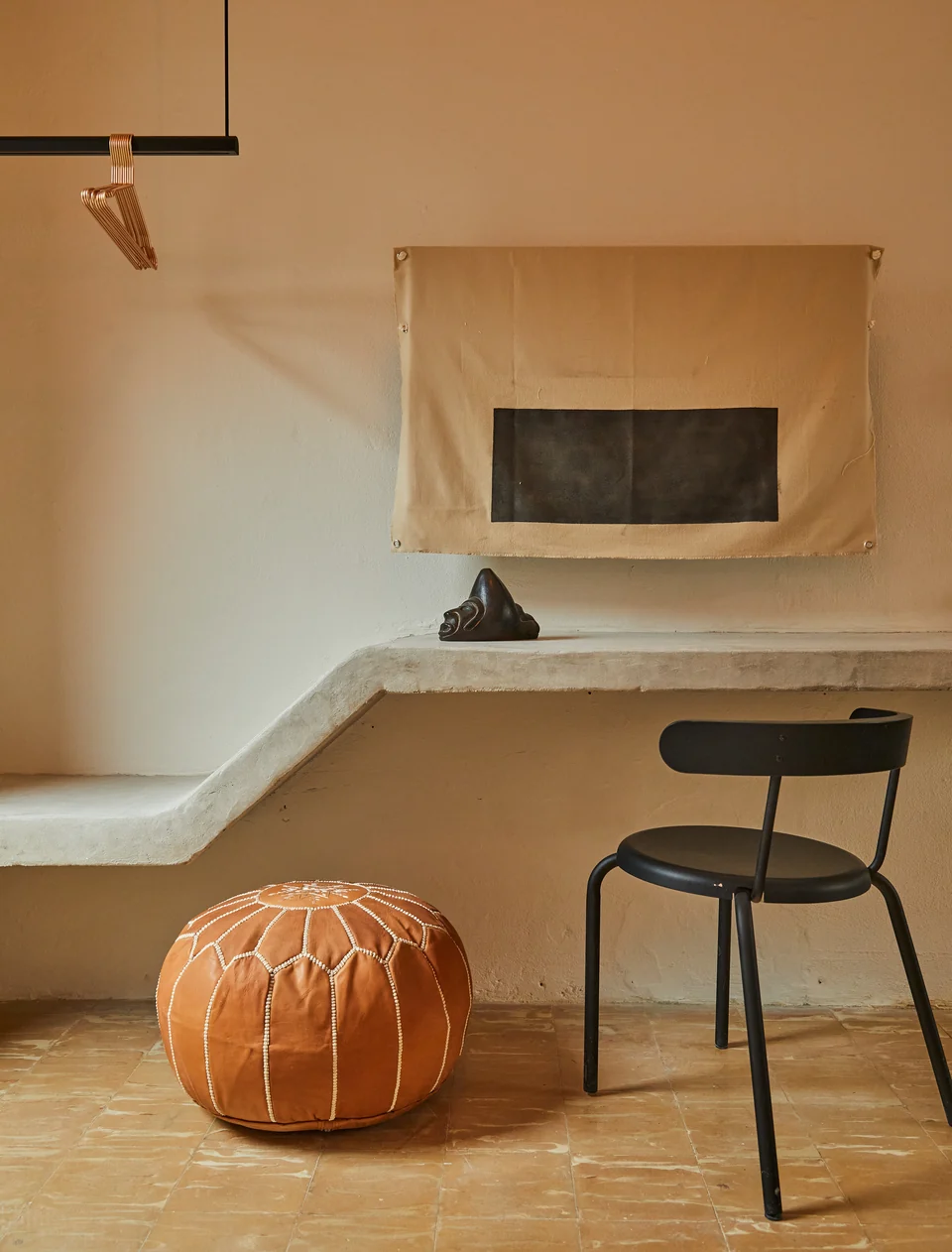 A concrete writing desk and woven stool in Rosa 2