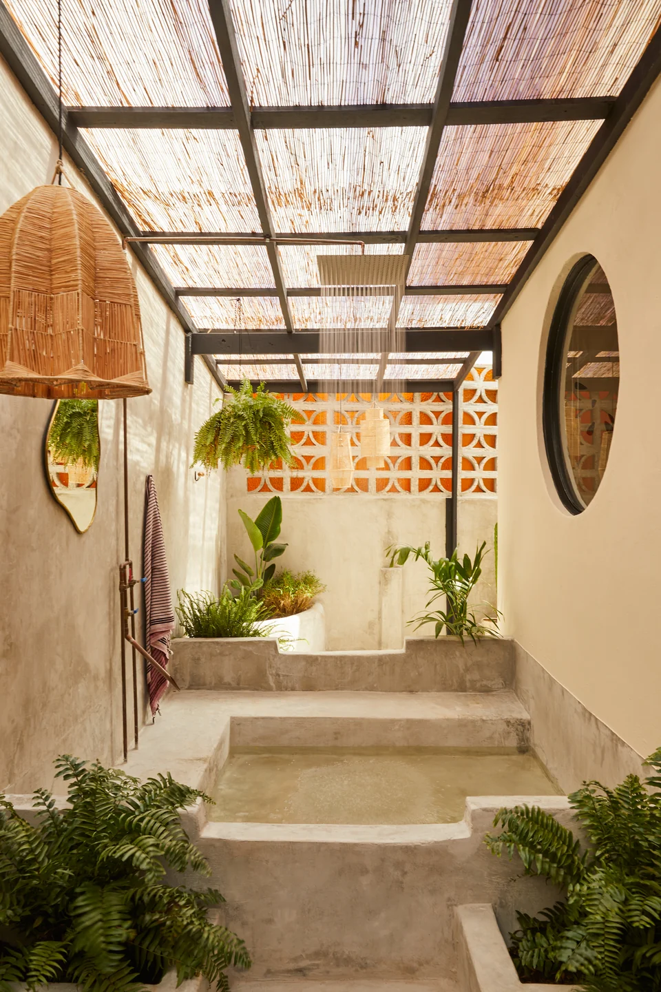 A custom concrete soaking tub beneath the slatted roof at Rosa 2