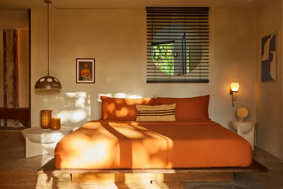 Terracotta textiles and warm light in Selva’s second bedroom