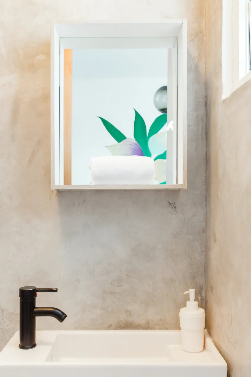 A concrete vanity and mirror in Adventurer’s first bathroom