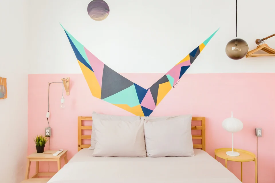 Adventurer’s second queen bedroom with a coral wall and geometric bird mural