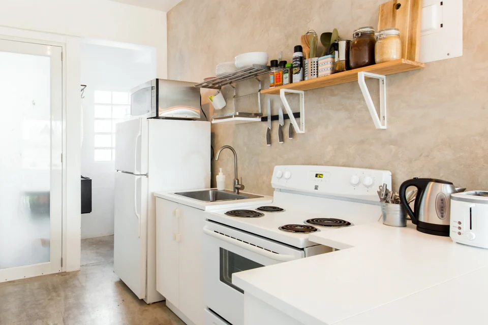 Adventurer’s full kitchen with a stove, oven, refrigerator and wood shelves