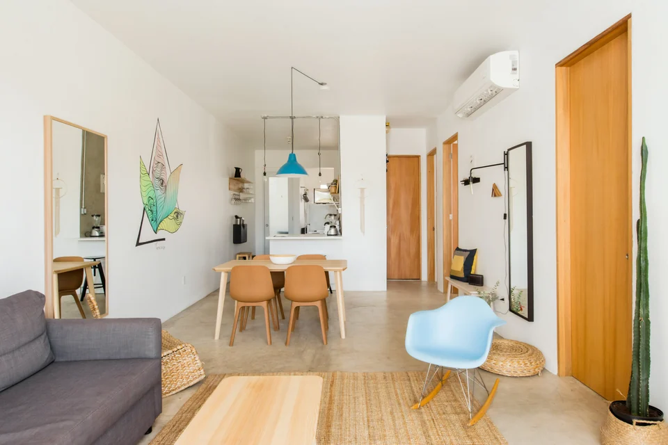 Adventurer’s open living and dining area with a gray sofa and blue chair