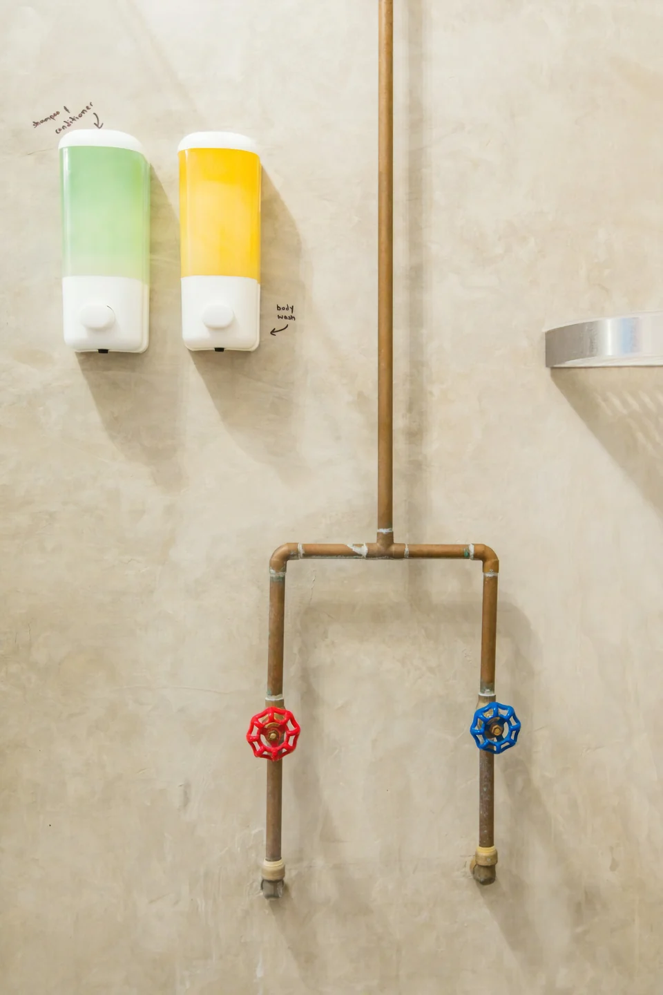 Copper pipes and bright tap handles in Adventurer’s rain shower
