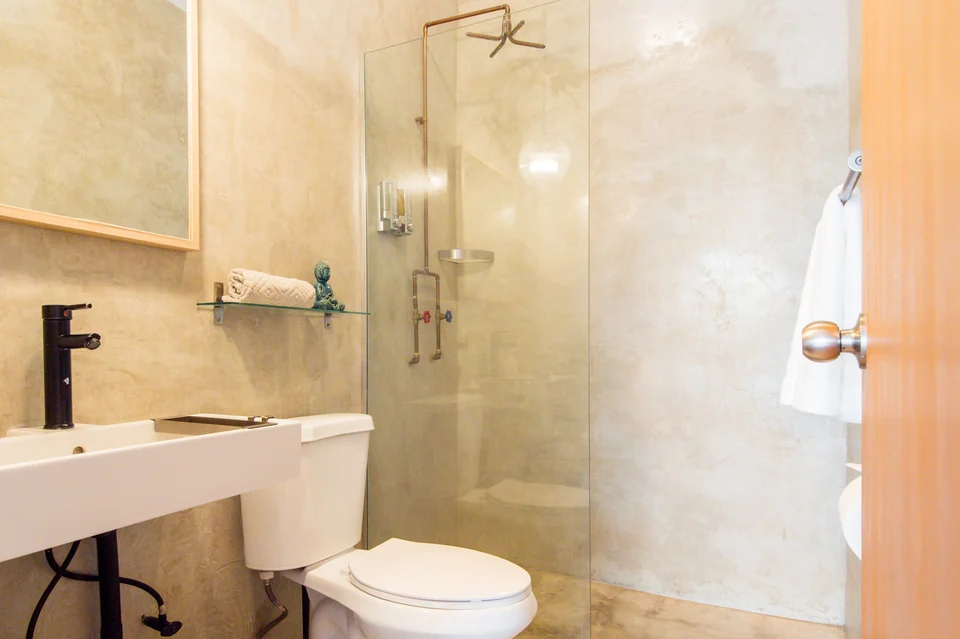Polished concrete and a custom copper shower in Dreamer’s second bathroom
