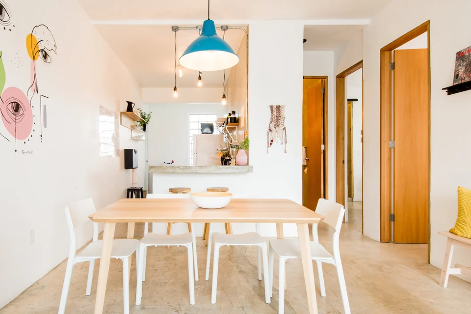 A long wooden dining table and blue pendant light in Dreamer