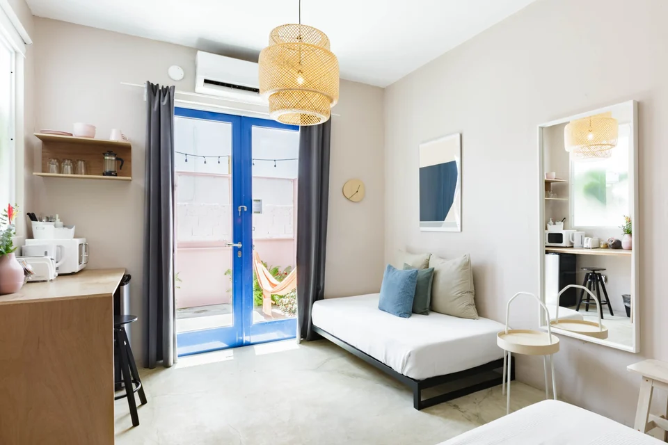 Lover’s daybed beside blue French doors and wood paneling