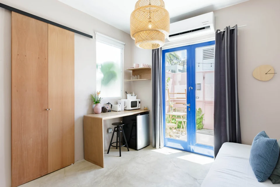 Lover’s compact kitchenette and daybed beside blue French doors