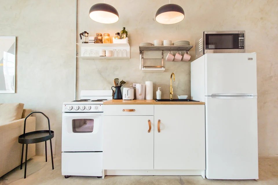 Nomad’s full kitchen with a stove, oven and refrigerator