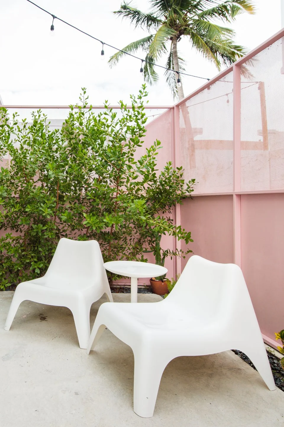 White chairs and tropical planting in one of Nomad’s private outdoor spaces