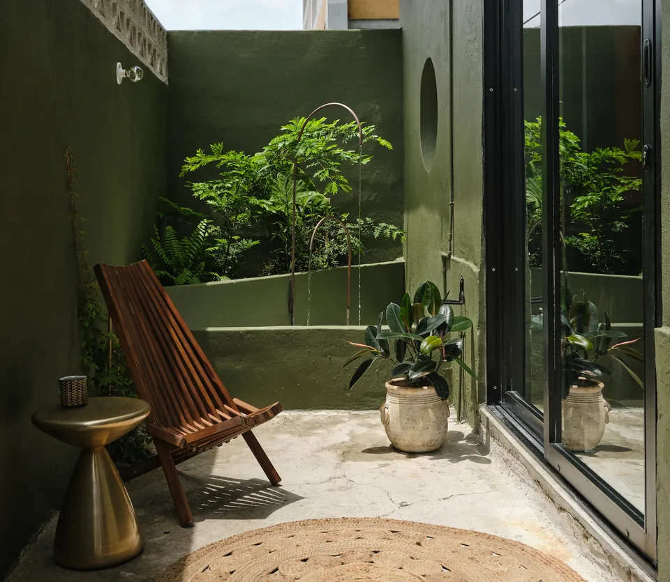 A wooden lounge chair and greenery on Verde 1’s private terrace