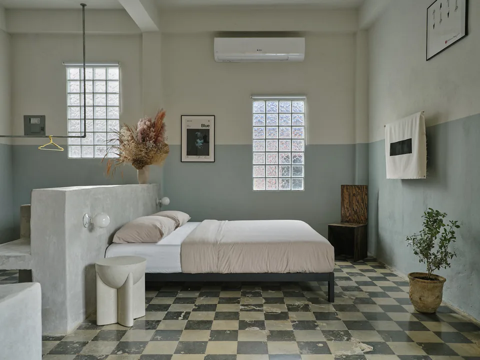King bed and concrete furnishings on checkered tile floors in Verde 1