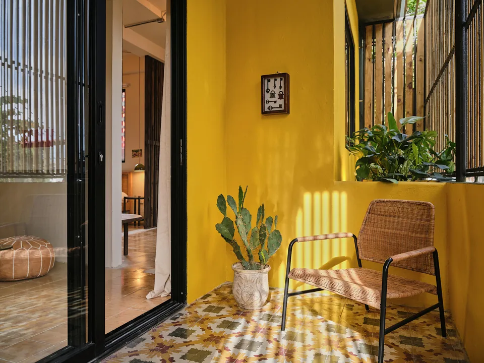 Yellow walls, wooden privacy slats and a chair on Verde 2’s front terrace