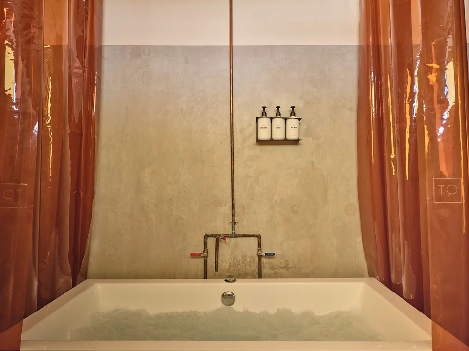 Verde 3’s soaking tub with a warm-colored shower curtain