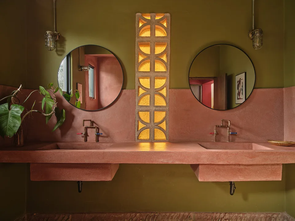 Double vanity in coral concrete and green walls in Verde 4’s bathroom