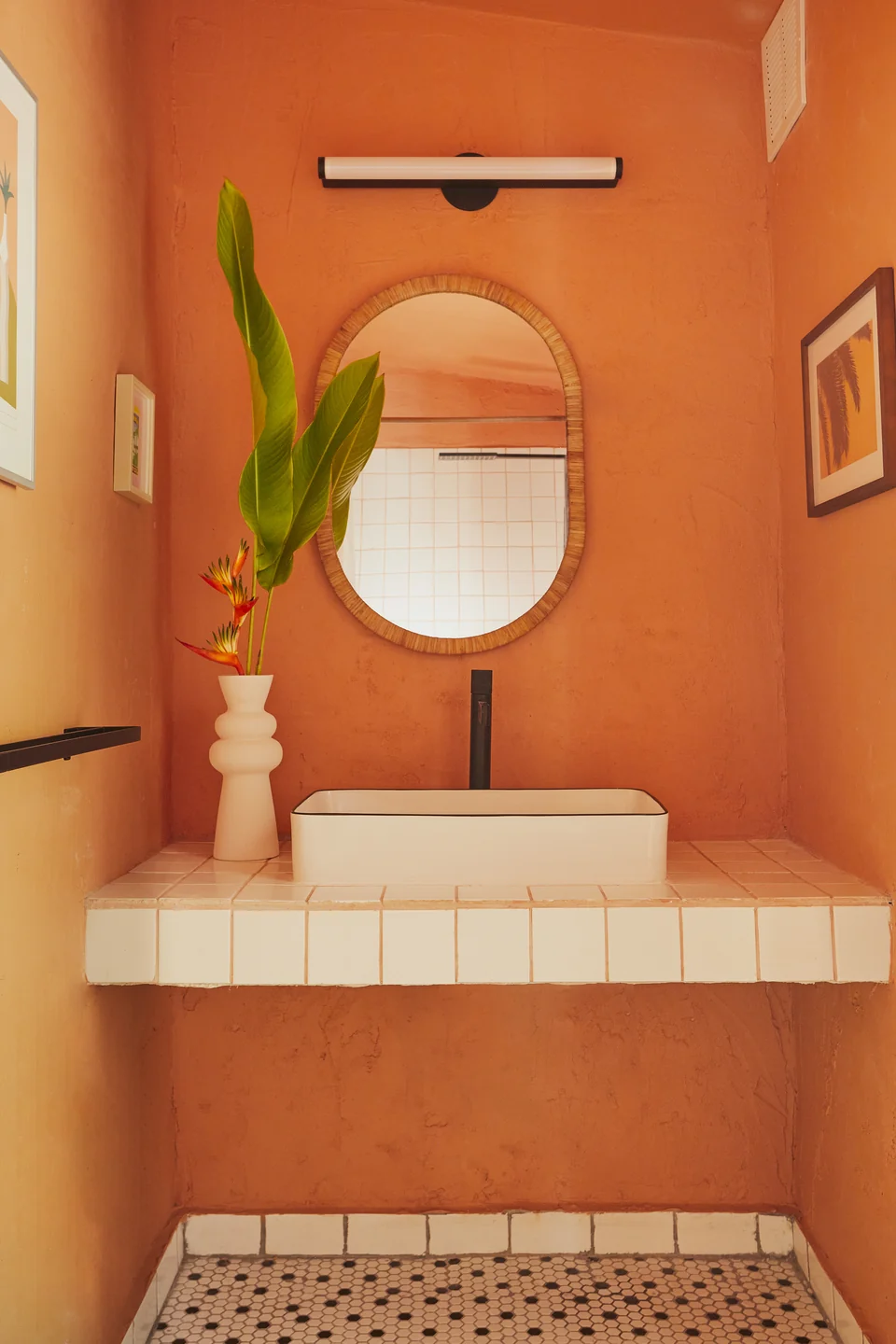 Terracotta walls, a round mirror and a tiled sink in one of Wald Haus’s bathrooms