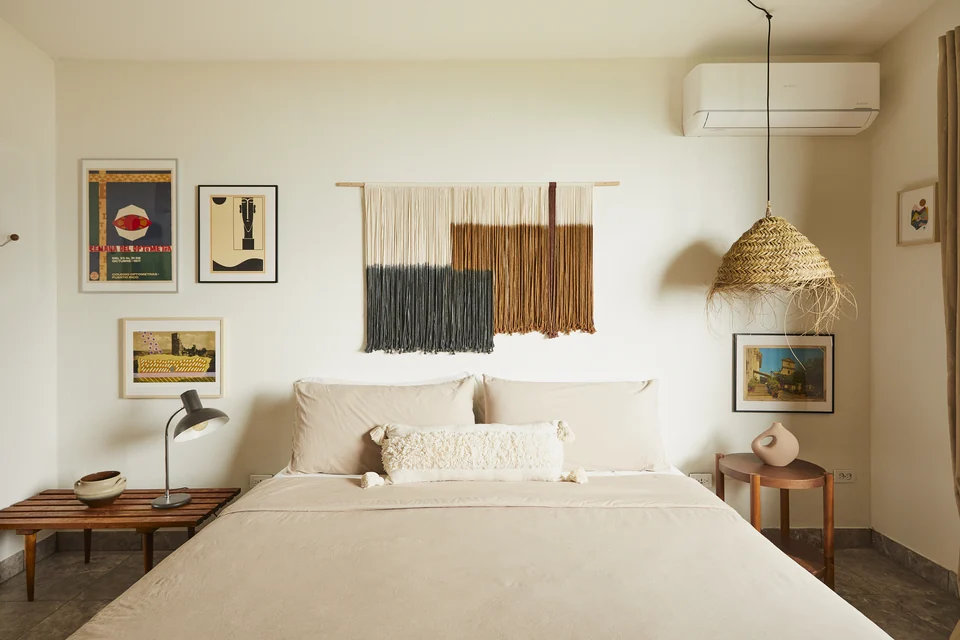 Cream bedding, woven shades and framed artwork in Wald Haus’s first bedroom