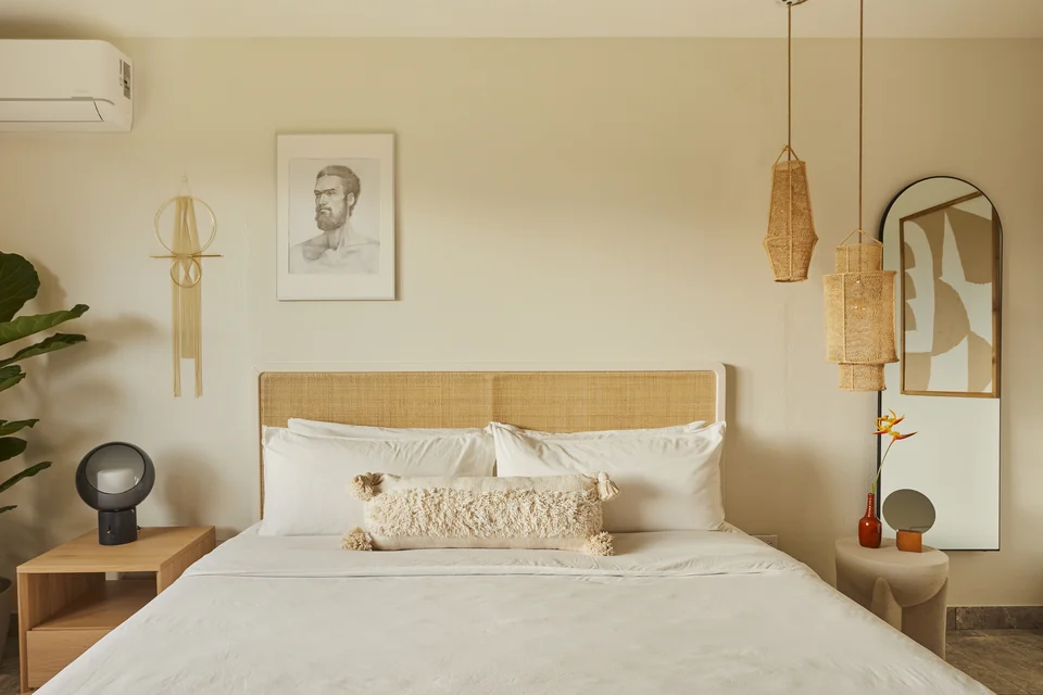 A woven headboard, pendant lamps and warm white walls in Wald Haus’s second bedroom