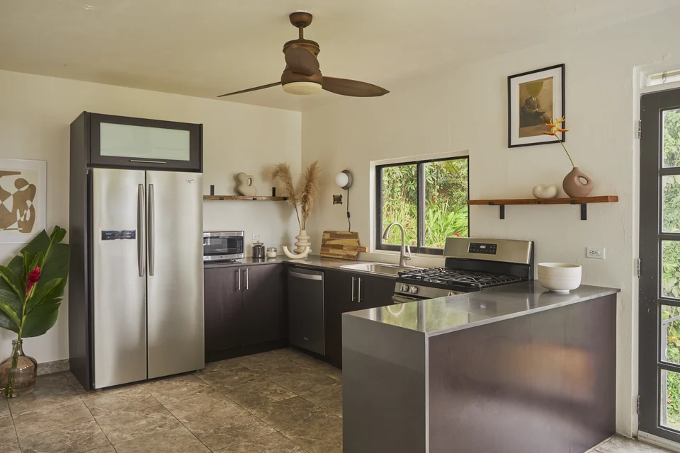 Dark cabinets, open shelves and garden-facing windows in Wald Haus’s full kitchen