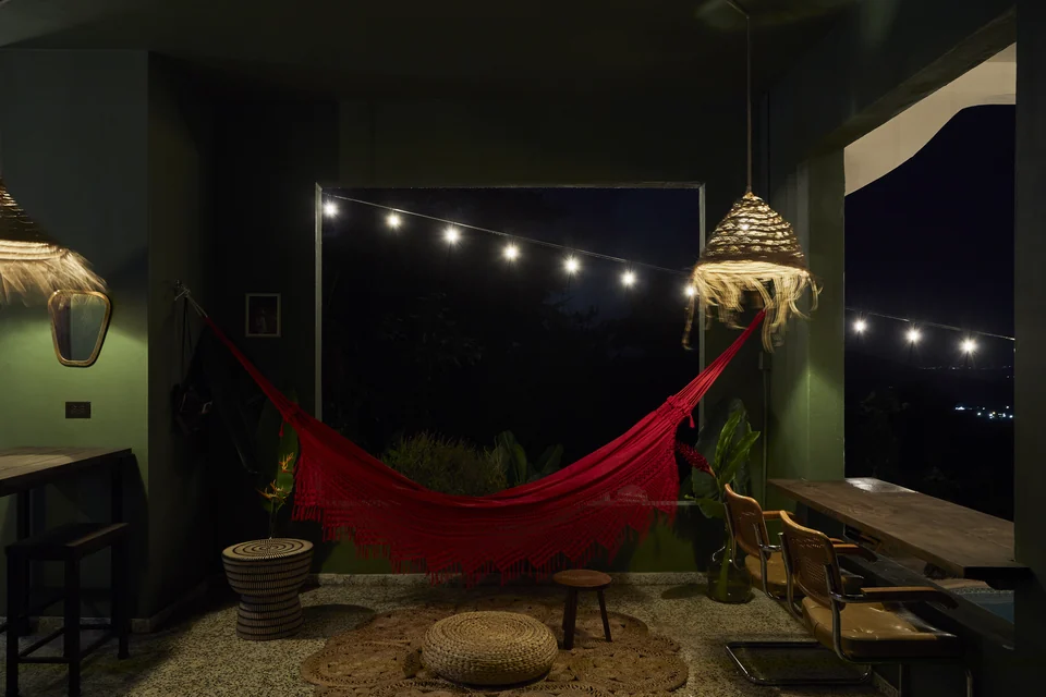 Wald Haus’s red hammock and green patio illuminated by string lights at night